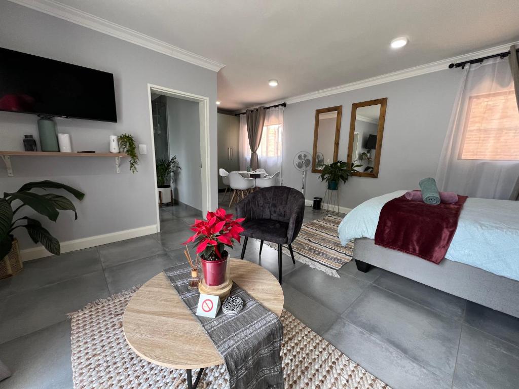 比勒陀利亚Afrique134 Olive Tree Private Courtyard Suite的卧室配有一张床和一张桌子