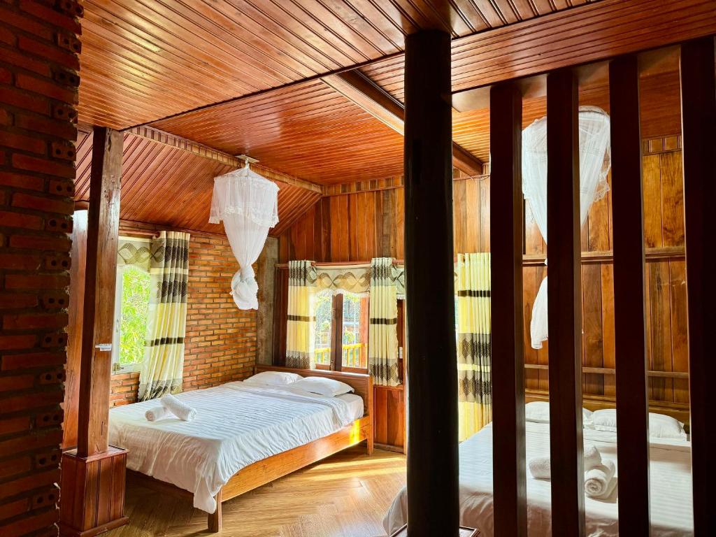 吉仙Lava Rock Viet Nam Lodge的一间带一张床的卧室,位于带木制天花板的房间内