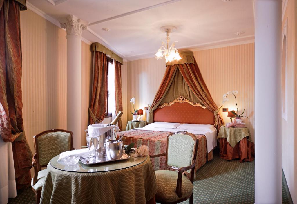 威尼斯凯特酒店的酒店客房配有一张床铺和一张桌子。