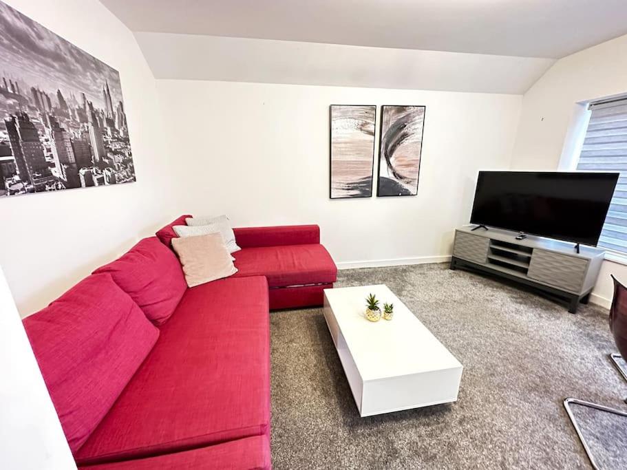 牛津Paradigm House, Delightful 2-Bedroom Flat 4, Oxford的客厅配有红色沙发和平面电视