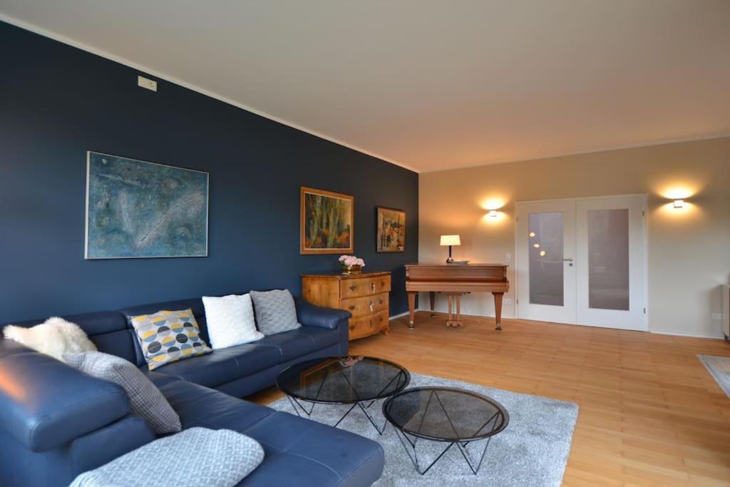 伍珀塔尔Luxurious Villa near Cologne, Düsseldorf and Essen的客厅配有蓝色的沙发和钢琴