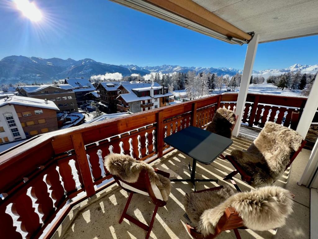 朗斯Exclusive Comfy Apartment in Central Crans-Montana的阳台配有椅子,享有白雪 ⁇ 的山景