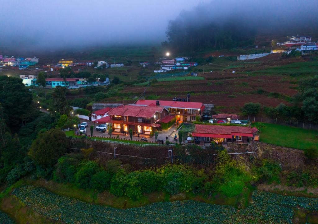 乌提Silent Valley Farm Resort Ooty by VOYE HOMES的夜空坐在山顶的房子