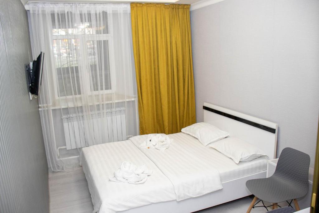 阿拉木图AG Hotel的卧室配有白色的床和窗户。