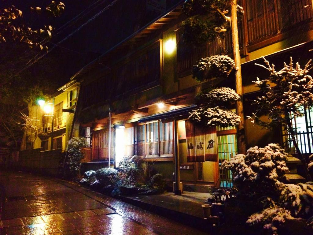 山之内町山崎屋旅馆的街上的一座建筑,晚上有灯