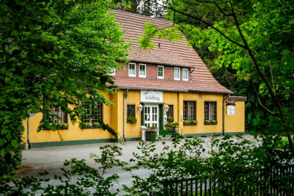 施洛斯霍尔特-斯图肯布罗克Hotel Holter Schloßkrug的黄色的房屋,有红色的屋顶