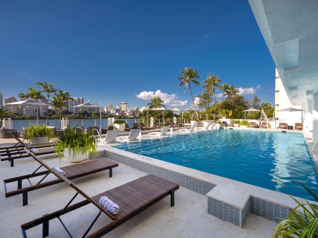 圣胡安Hilton Garden Inn San Juan Condado的一座带躺椅和躺椅的游泳池