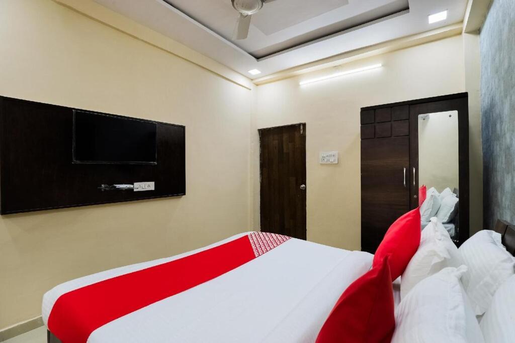 NarodaHotel Sunrise的卧室配有红色和白色的床以及平面电视。