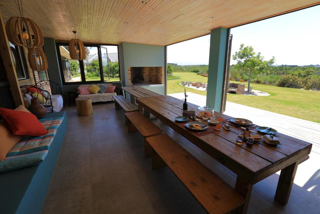 普利登堡湾Gemstone Farm的客厅设有一张木桌和大窗户