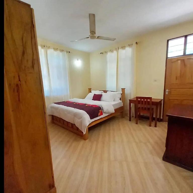 Sinthia Apartments的一间卧室配有一张大床和一张桌子