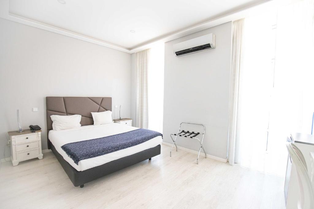 里斯本阿露比雅格兰德盘沙住宅酒店的白色卧室配有床和椅子