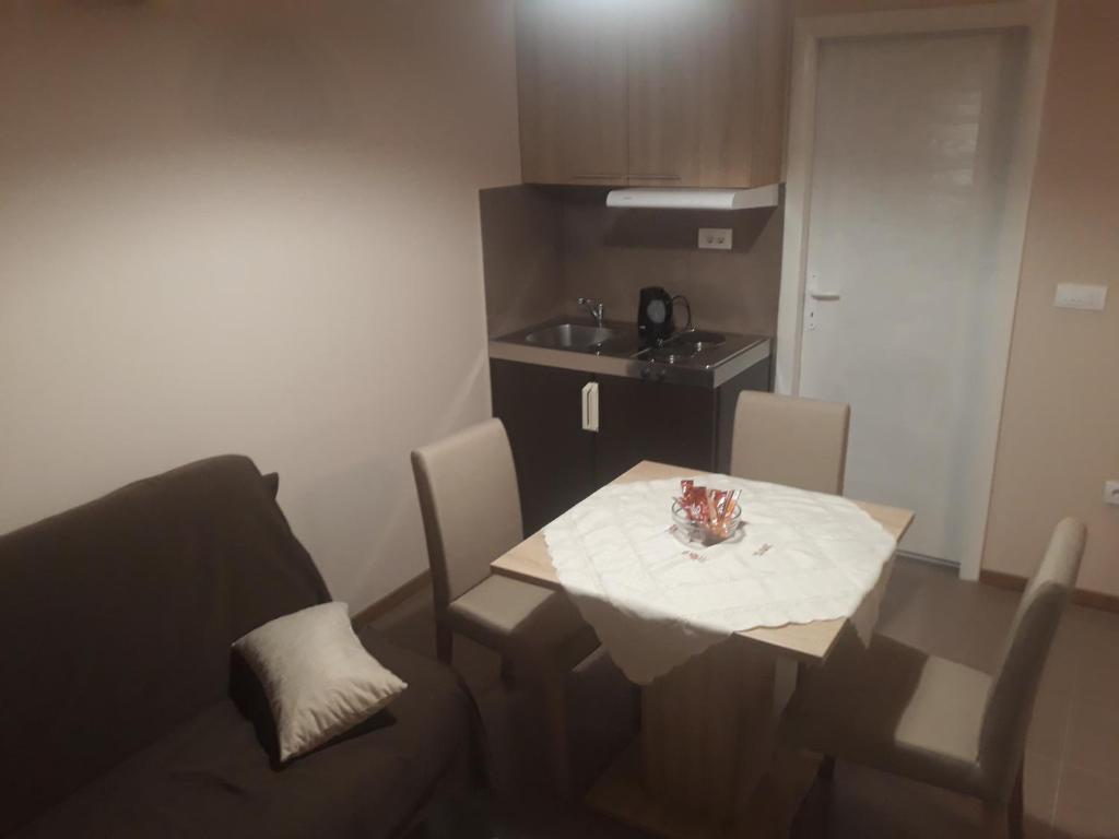 沙巴茨Apartmani J&J的小房间设有桌椅和厨房
