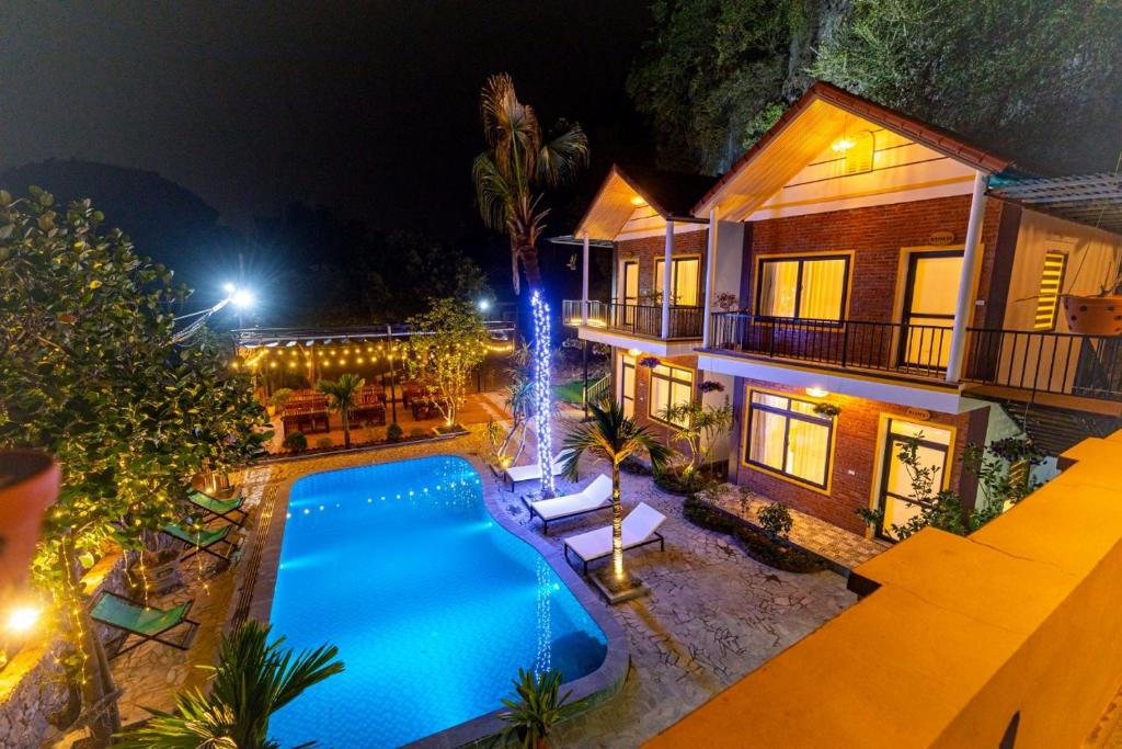 宁平Tam Coc Green Mountain Homestay的享有带游泳池的房屋的空中景致