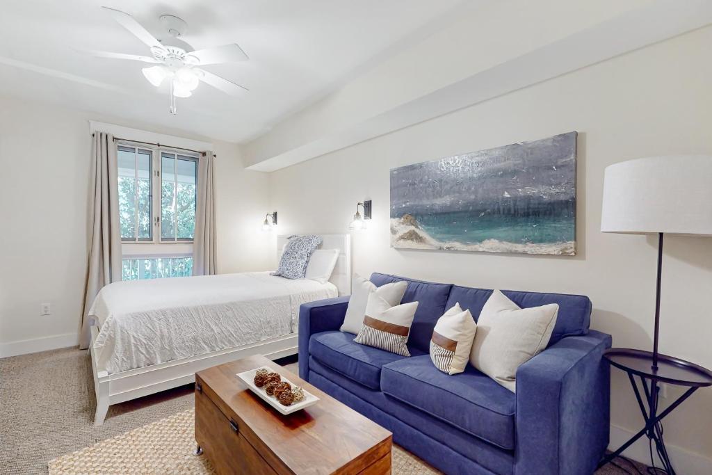 德斯坦Baytowne Wharf - Pilot House #207的客厅配有蓝色的沙发和床。