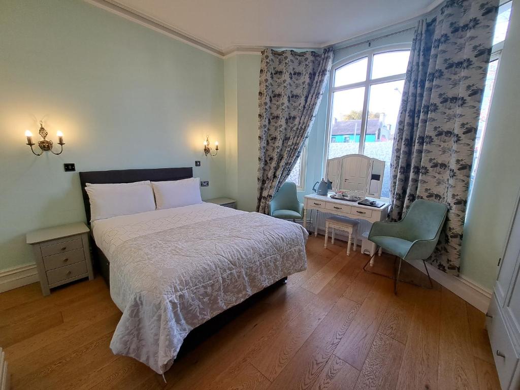 科克山顿贝尔酒店的一间卧室配有一张床、一张书桌和一个窗户。