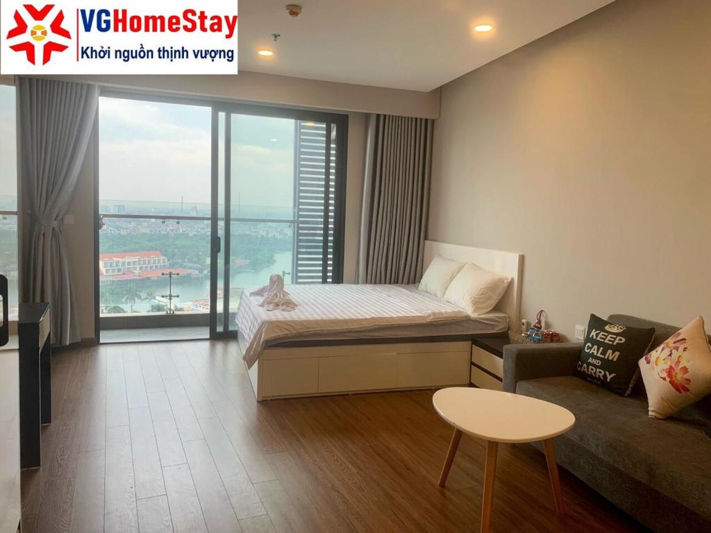 海阳Apec Mandala hotel & suites Hải Dương的一间卧室配有一张床、一张沙发和一个窗口