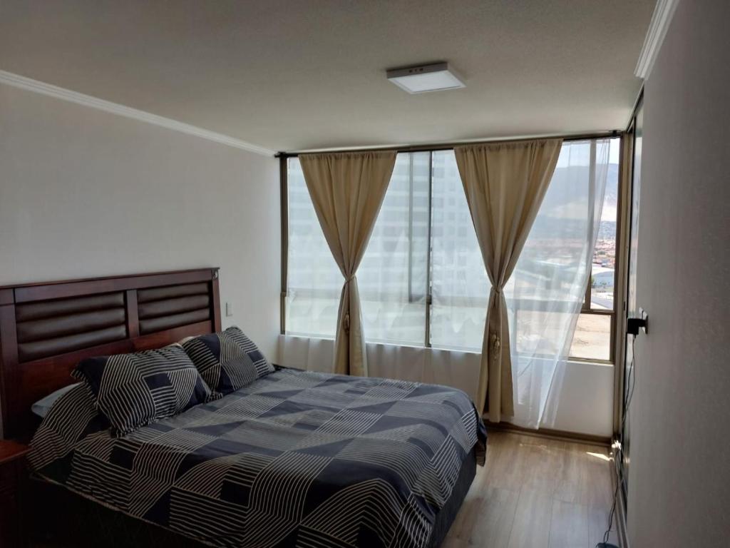 安托法加斯塔El Faro Antofagasta的一间卧室设有一张床和一个大窗户
