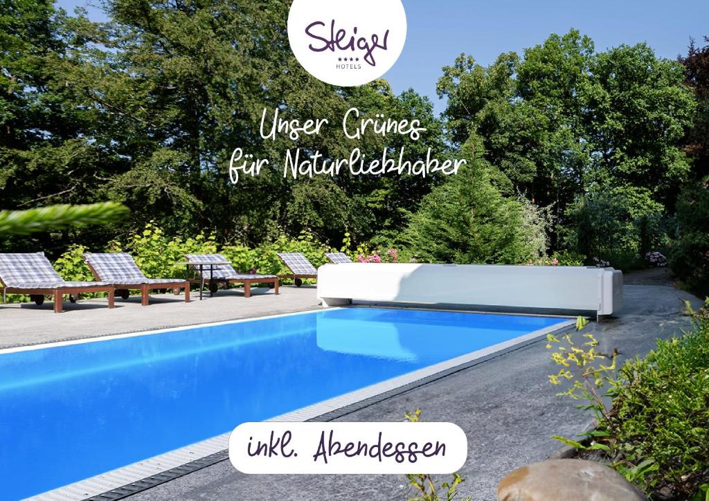 巴特尚道STEIGER Parkhotel Hohnstein的院子里的游泳池,上面有标志,说自然建筑者更聪明地生活