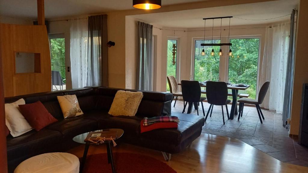 MossautalFerienwohnung Hammergrund的带沙发的客厅和用餐室
