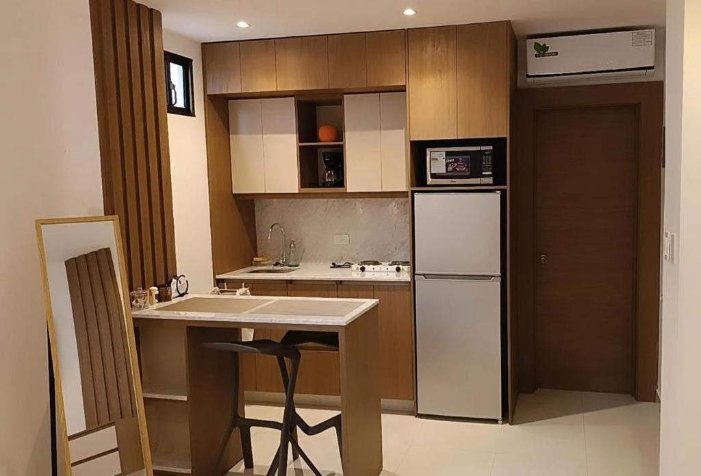 瓜亚基尔NOVAPARK HOTEL的厨房配有白色冰箱和桌子