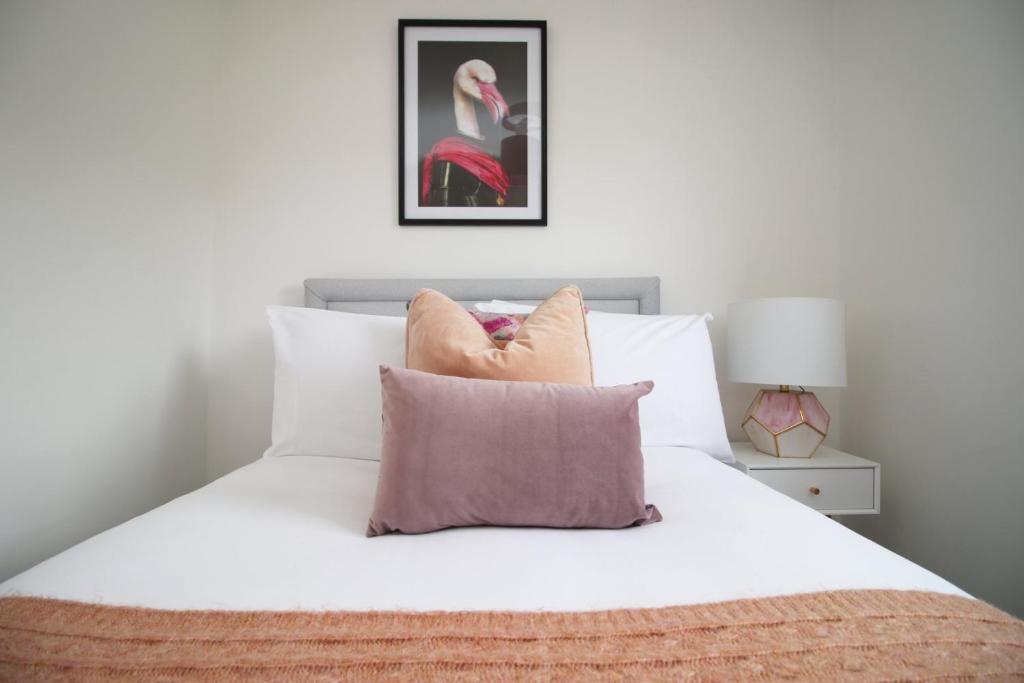 布里斯托4 BR with FREE on street parking的一间卧室配有带白色床单和枕头的床。