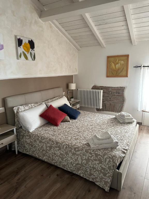 维泰博DOMUS TUSCIA APARTMENTS San Faustino guesthouse的一间卧室配有一张带红色和蓝色枕头的大床