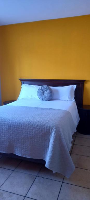 勒斯滕堡Platinum gem in the City of Rustenburg的卧室配有白色床和黄色墙