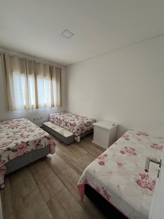 尚格里拉Casa com Piscina em Xangri-Lá RS的一间卧室设有两张床和窗户。