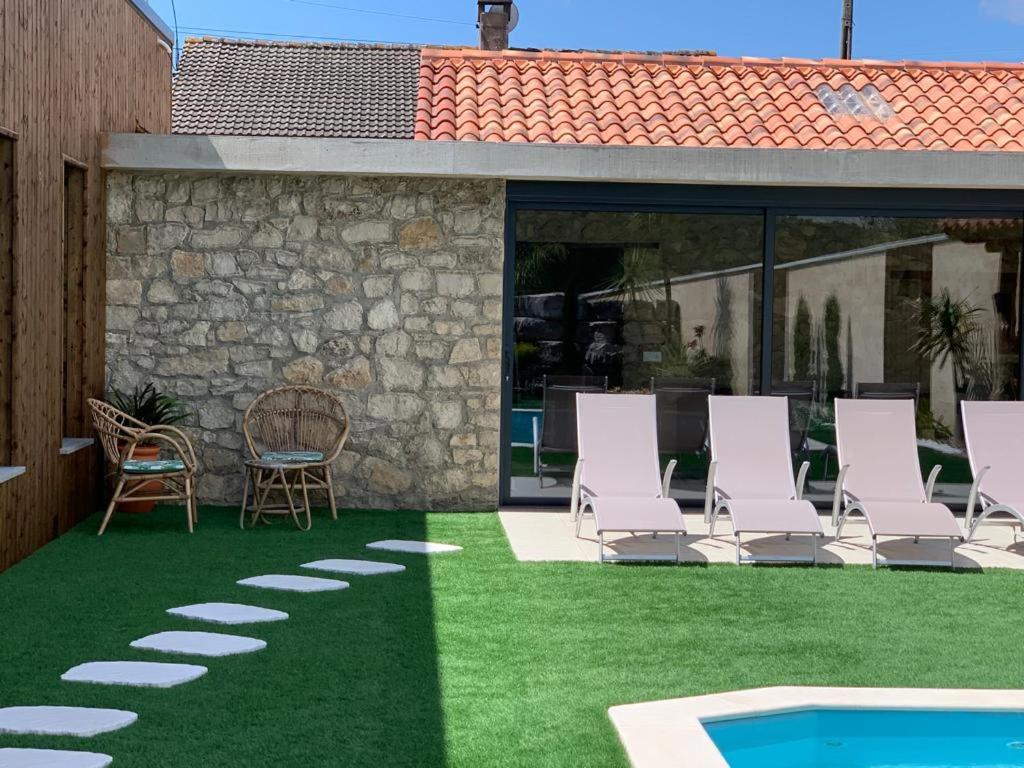 Adega D'Aldeia的一个带草坪椅和游泳池的庭院