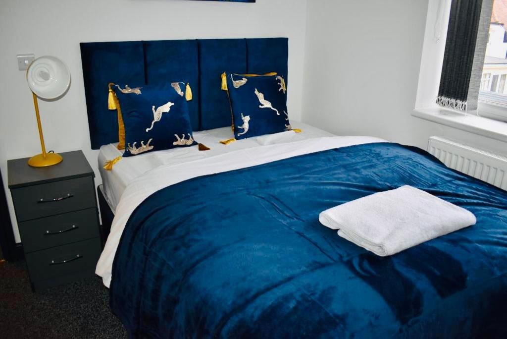 比斯顿Beeston House 3 BR and FREE Parking的一间卧室配有蓝色的床和蓝色的毯子