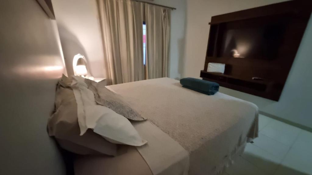 锡诺普Apartamento Confortável e Espaçoso的酒店客房配有带枕头的床和电视。