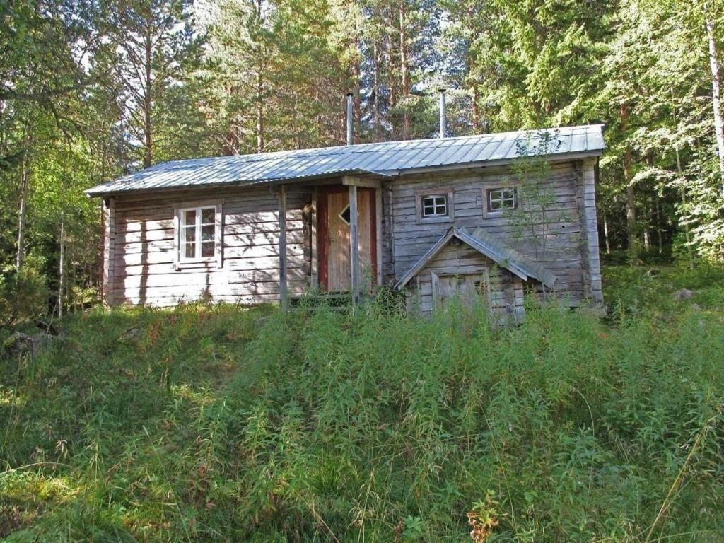 YtterhogdalEinfache Holzhütte für das wahre Naturerlebnis am Stausee的田野中间的小木房子