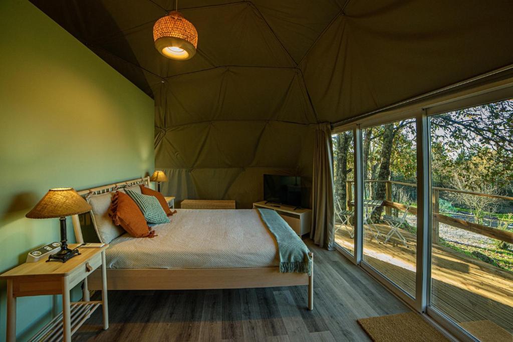 卡纳斯·德·塞尤里Manteiros Glamping的帐篷内的卧室,配有一张床和一张书桌