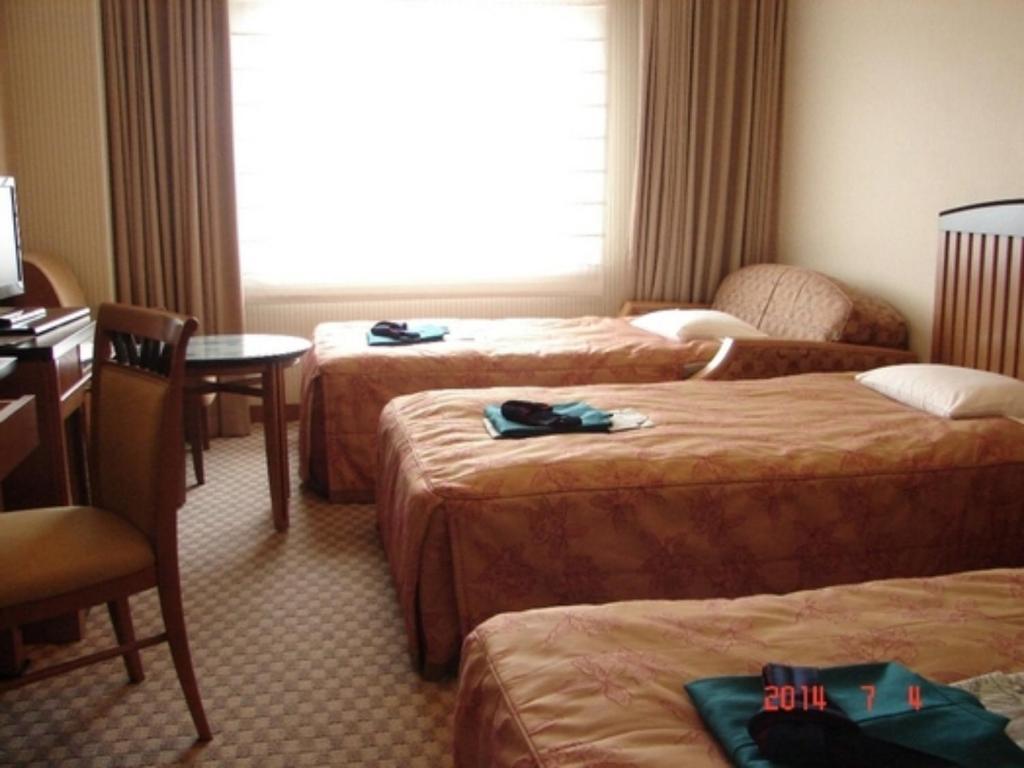 TōnoAeria Tohno - Vacation STAY 62231v的酒店客房设有三张床、一张桌子和一扇窗户。