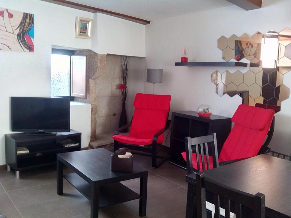 圣地亚哥－德孔波斯特拉霍塔斯公寓的客厅配有红色椅子和桌子