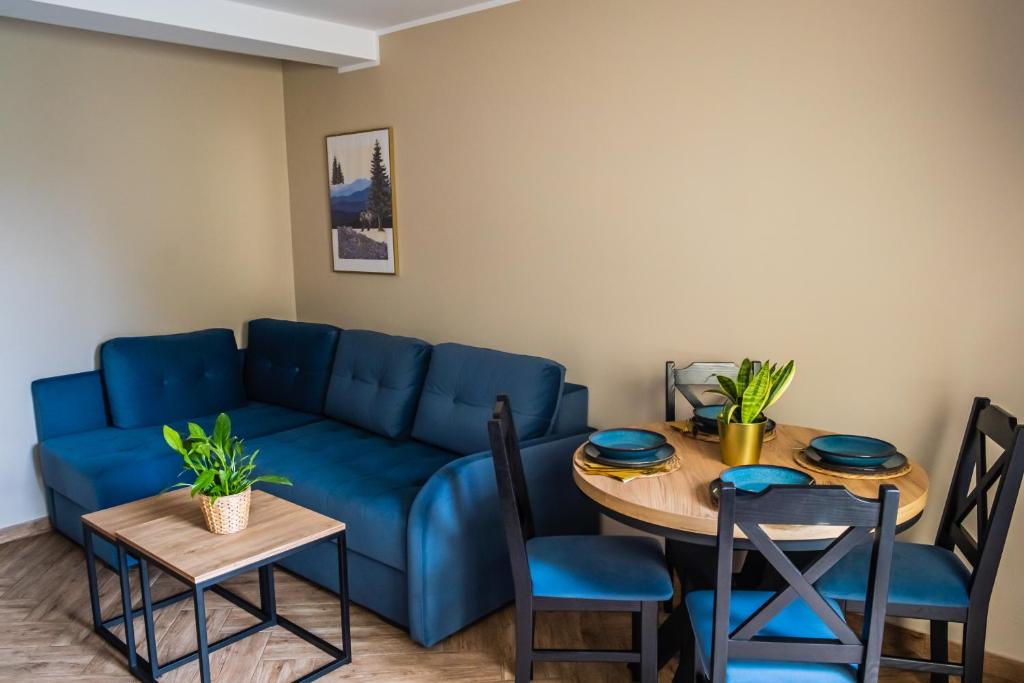 斯蒂格纳Pokoje Siódemka的客厅配有蓝色的沙发和桌子