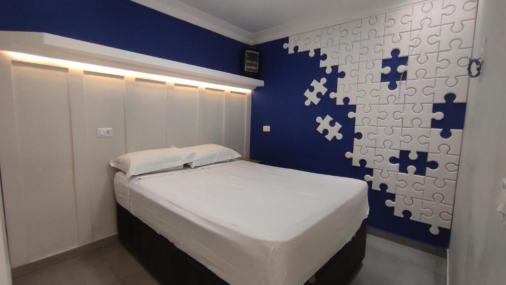 库里提巴Family House - Curitiba的一间卧室配有一张蓝色墙壁的床