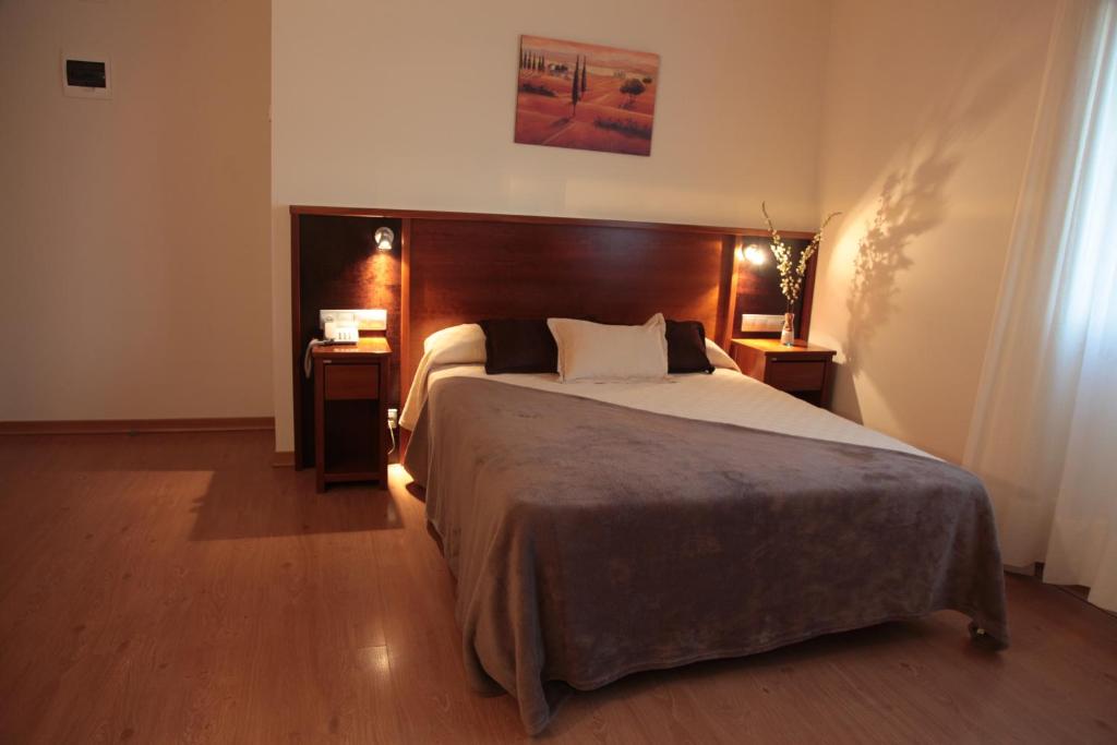 圣西普安－德比尼亚斯圣西伯来酒店的一间卧室设有一张大床和两个床头柜