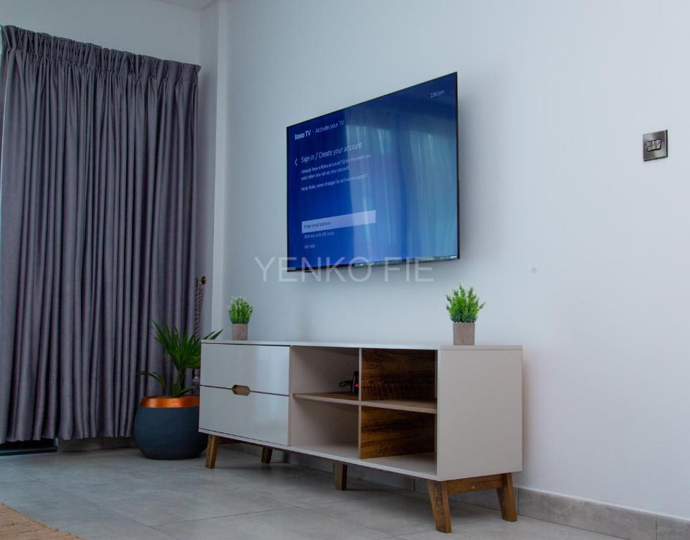 阿克拉Yenko Fie Suites: The Signature Apartments, Accra Ghana的客厅的墙上配有电视