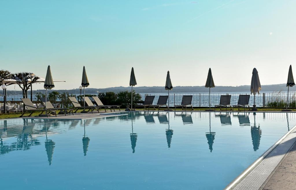 西尔米奥奈玛诺达酒店的一个带椅子和遮阳伞的大型游泳池
