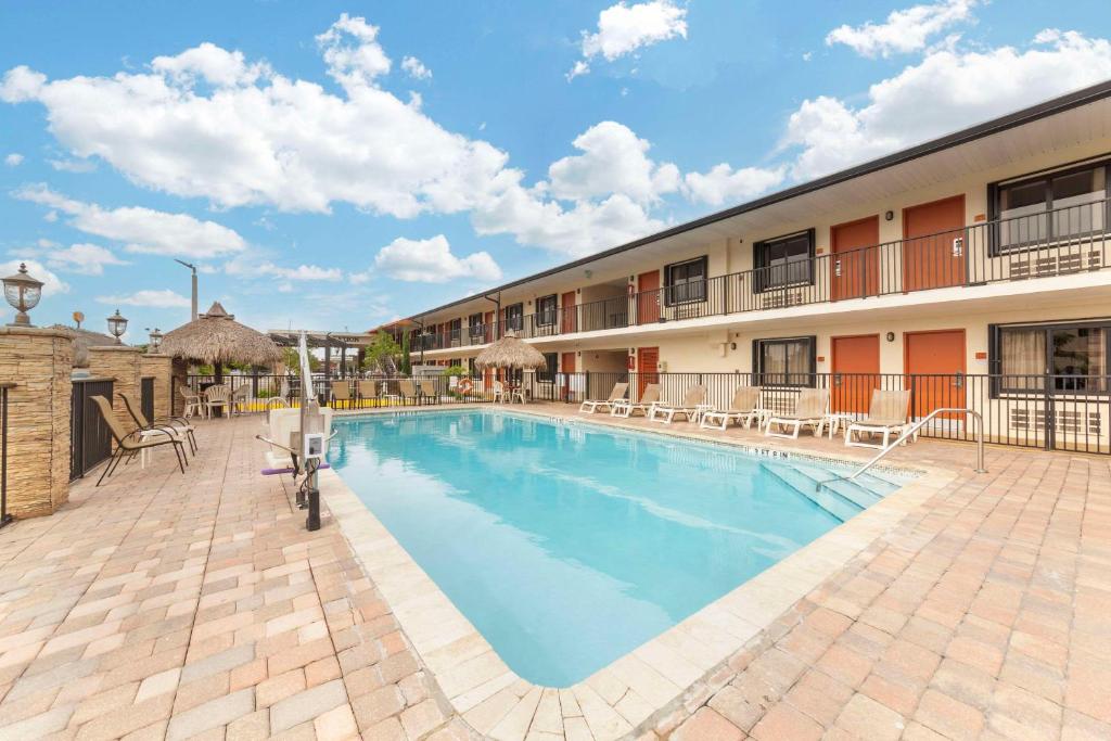 佛罗里达市Quality Inn Florida City - Gateway to the Keys的一座带椅子的酒店游泳池以及一座建筑