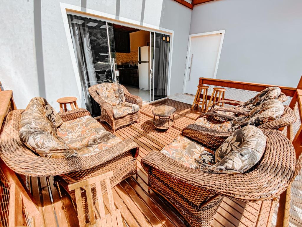 弗洛里亚诺波利斯Morada da Lagoinha的客厅配有柳条家具,位于木甲板上