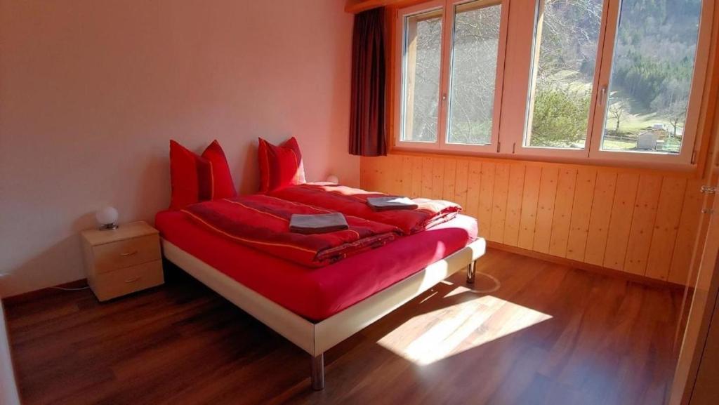 因内特基尔兴Wohnung mit 3 Schlafzimmern Wylerdümen的一间卧室配有一张带红色床单的床和一扇窗户。