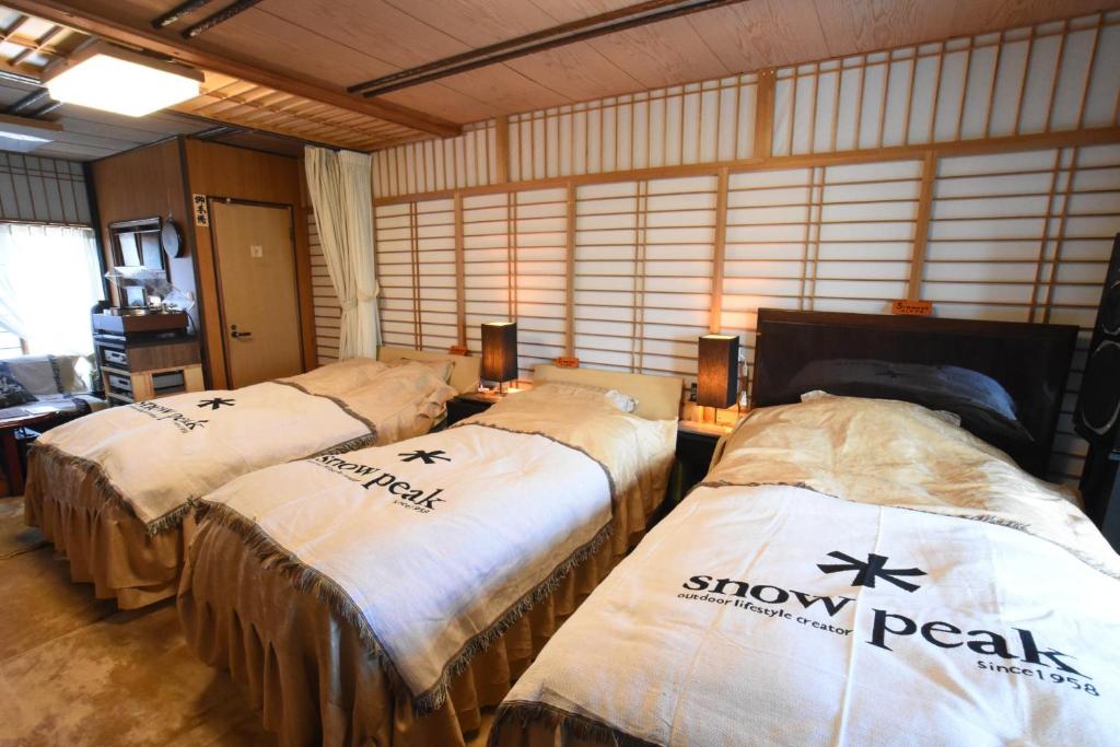 佐渡市Natural Mind Tour guest house - Vacation STAY 22268v的一间房间,配有三张床,上面有雪花