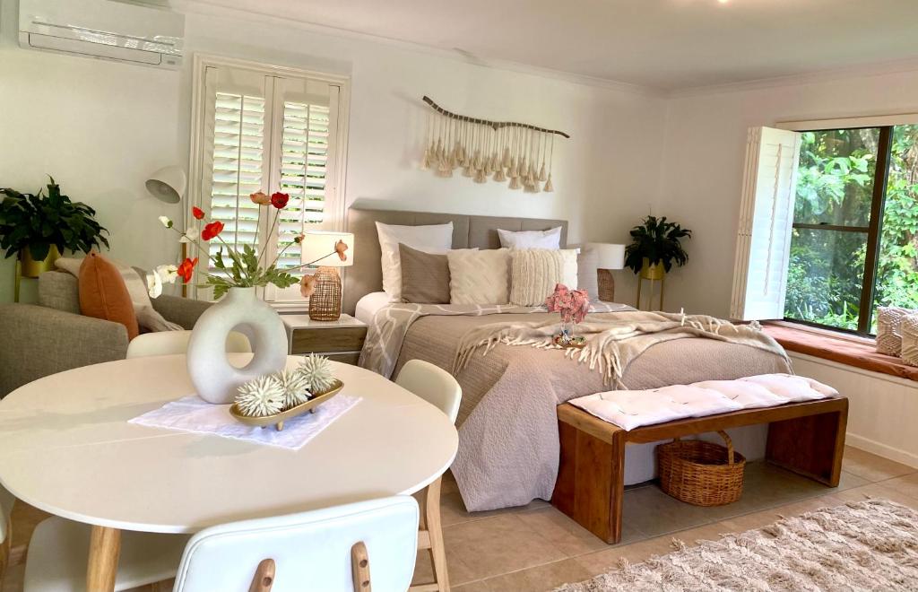 马莱尼Maleny Lake Cottages的一间卧室配有一张床、一张桌子和一张沙发