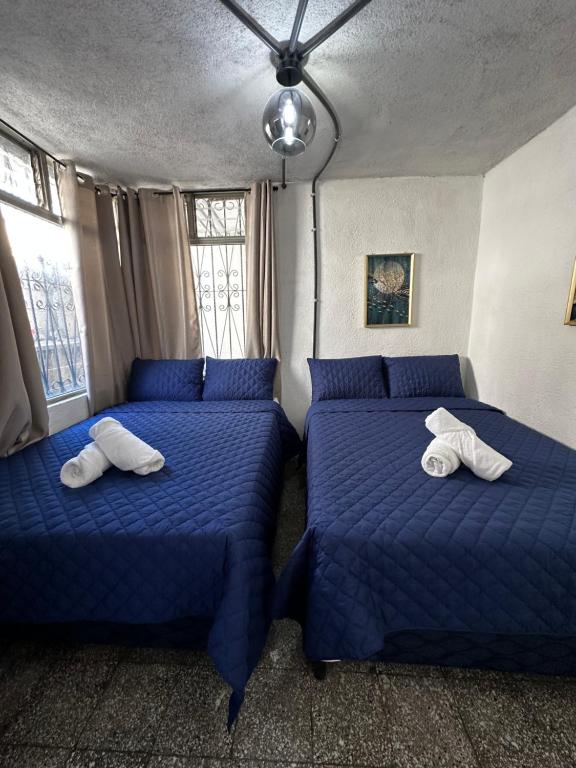 危地马拉CASA MAGNOLIA的配有蓝色枕头的客房内的两张床
