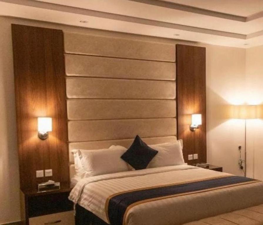 Al Qubsahنايس هوم的一间卧室配有一张大床,两盏灯