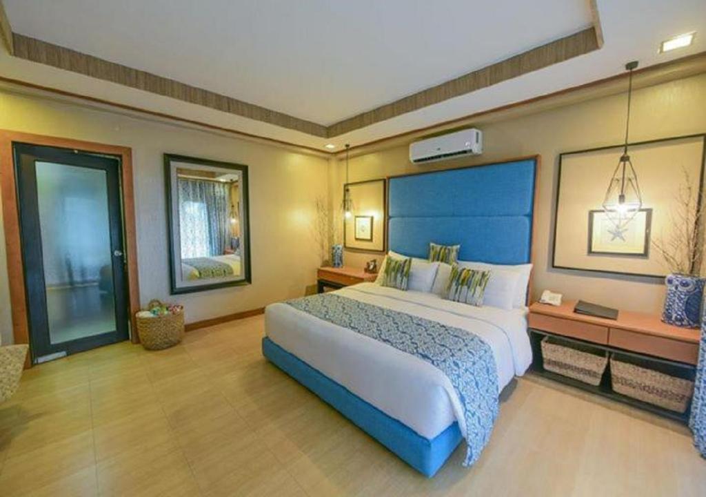 Colongcocon图嘎维考夫度假酒店的大卧室设有一张带蓝色床头板的大床