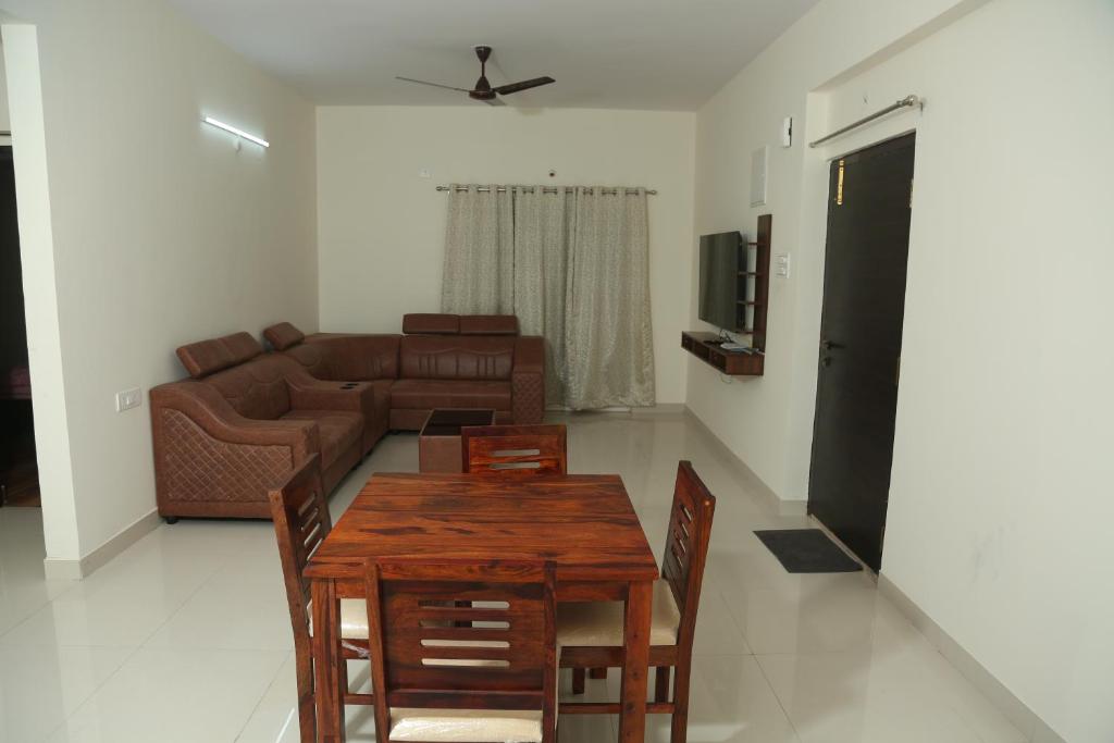 海得拉巴Mee Homes - Madhapur Fully Furnished 2 BHK Flats的客厅配有木桌和沙发