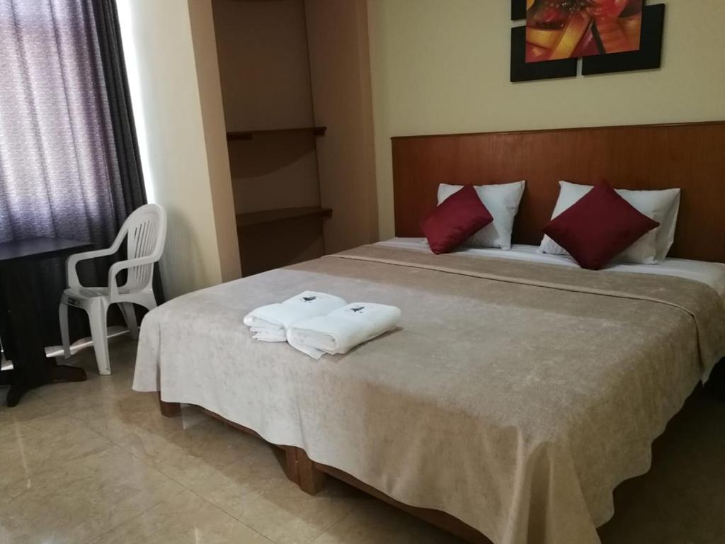 卢那欢纳Hostal Aventura Total Perú_lunahuana的一间卧室配有一张床,上面有两条毛巾